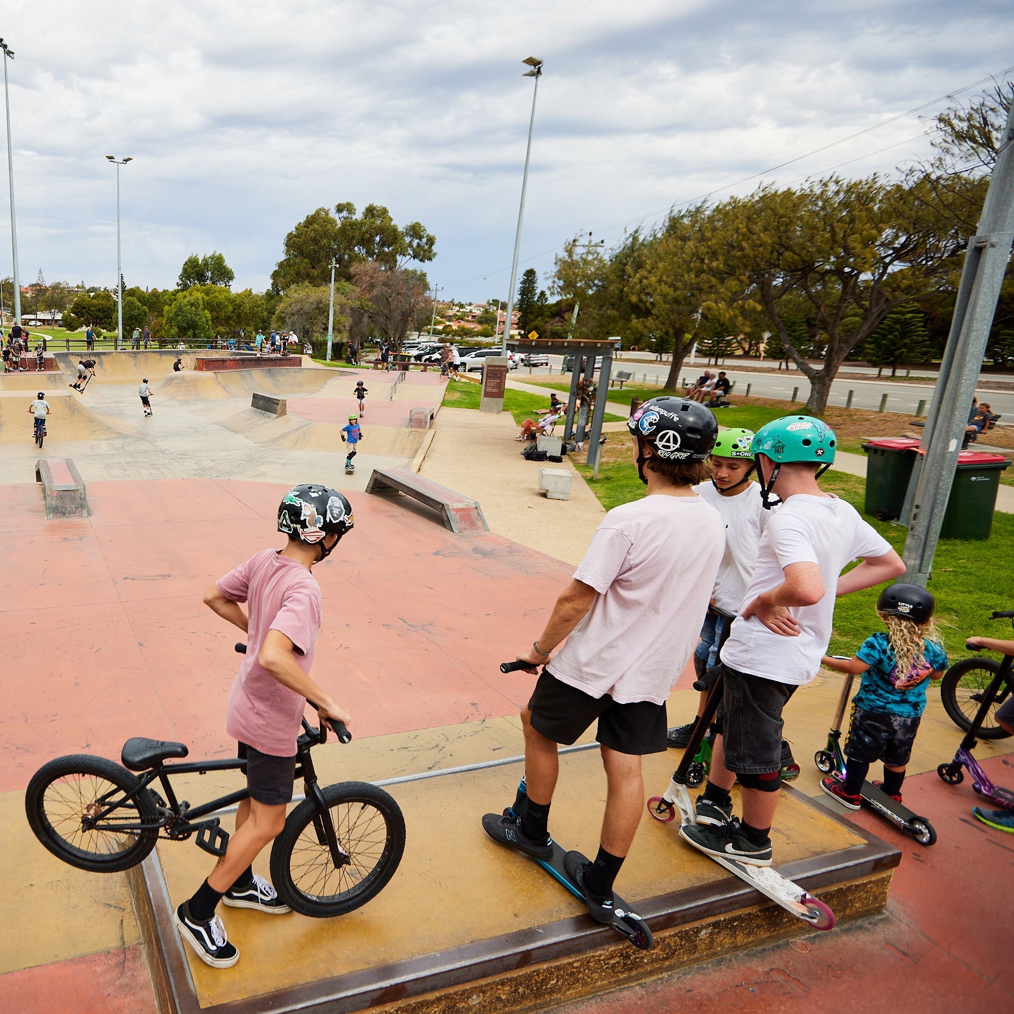 BMX rider and freestyle scooter rider at skatepark